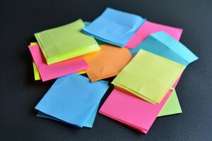 Colorful sticky notes scattered on a dark surface during a brainstorming session photo
