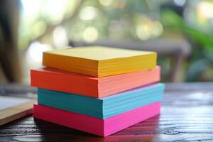 Colorful stack of note cards on a wooden table in a bright, sunny room photo