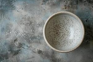 A speckled ceramic bowl on a textured gray background photo