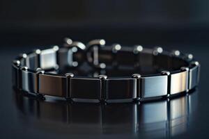 Sleek black bracelet on a reflective surface with elegant detailing captured in soft lighting photo