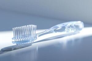 Transparent toothbrush resting on a reflective surface with soft lighting photo