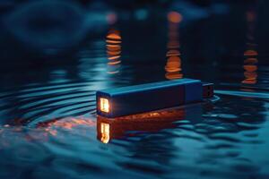 A blue USB drive floats on water, illuminated by ambient lights during dusk photo