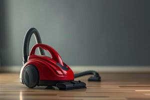 A red vacuum cleaner on polished wooden flooring in a well-lit room photo