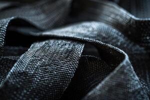 Close-up of textured black fabric draping artistically with soft light reflecting on its surface photo