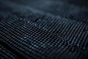 Close-up view of textured black fabric showcasing intricate weave patterns in natural lighting photo