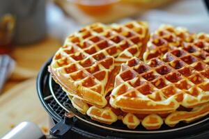 Freshly made waffles stacked on a waffle iron in a cozy kitchen setting during breakfast time photo