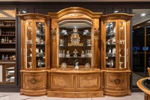 Elegant wooden display cabinet showcasing fine glassware and decorative items in a modern living space during the evening photo
