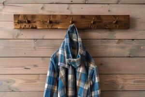 Cozy flannel coat hanging on wooden hooks in a rustic interior setting photo