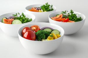 Freshly prepared vegetable salads in white bowls arranged on a light surface photo
