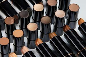 A collection of lipsticks in various shades arranged neatly on a smooth surface photo
