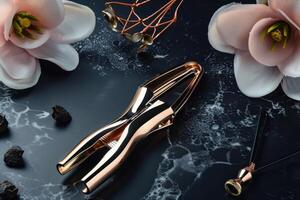Elegant rose gold eyelash curler placed among decorative flowers on a marble surface photo