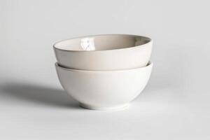 Two simple ceramic bowls stacked together on a light background for minimalist kitchen decor photo