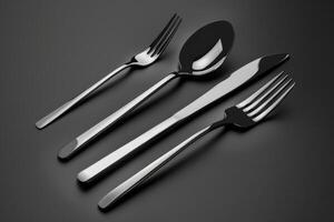 Elegant stainless steel cutlery set arranged neatly on a dark background for dining purposes photo