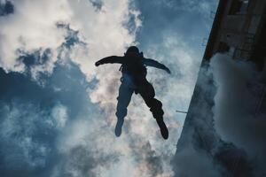 Person jumps from a building into the clouds during an extreme sports event in the city photo