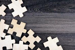 puzzle elements on a wooden background as a riddle photo