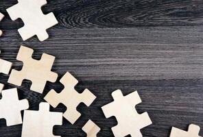puzzle elements on a wooden background as a riddle photo