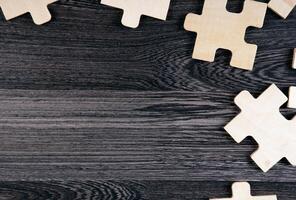 puzzle elements on a wooden background as a riddle photo