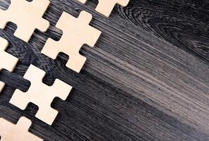 puzzle elements on a wooden background as a riddle photo