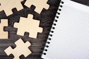 open notepad with puzzle pieces on a table photo