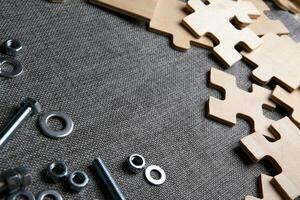 puzzle elements on a textile background and and steel nuts, bolts photo