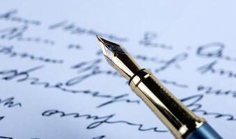 fountain pen on paper with ink text on the paper photo