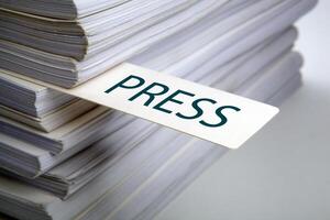 bookmark labeled press in a stack of documents concept photo