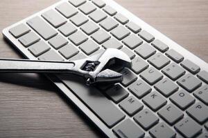 big adjustable wrench and a computer keyboard close up photo