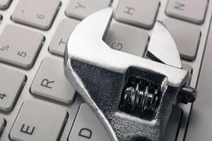 big adjustable wrench and a computer keyboard close up photo