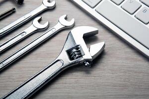 big adjustable wrench and a computer keyboard close up photo