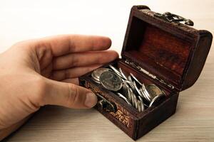 human hand next to a small chest of Russian ruble coins photo