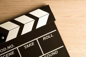 black movie clapper on a wooden background top view photo