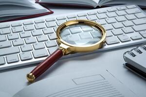 magnifying glass on the pc keyboard search technology concept photo
