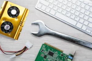 big wrench and a computer keyboard and computer parts photo
