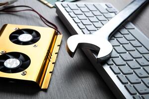 big wrench and a computer keyboard and computer parts photo