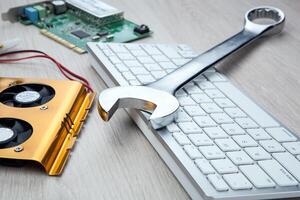 big wrench and a computer keyboard and computer parts photo