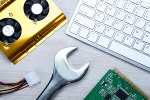 big wrench and a computer keyboard and computer parts photo