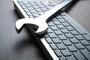 big wrench and a computer keyboard close up photo