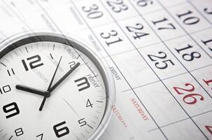 wall calendar with the number of days and white clock face photo