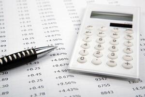 calculator with numbers and pen on the desktop photo
