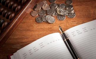 fountain pen and diary on a table with an abacus and ruble coins photo