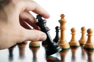 the chess player's hand holds the chess piece of the black king and defeat photo