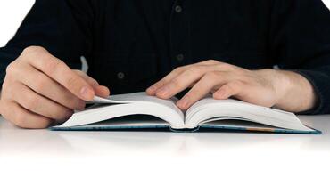 Man's hands and man looking for something in the book photo