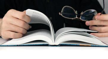 Man's hands and man looking for something in the book photo
