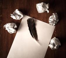 still life of paper and a crumpled paper on a table with a pen photo