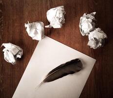 still life of paper and a crumpled paper on a table with a pen photo