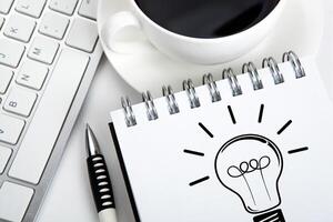 business still life of a notebook with an icon of idea and keyboard on the desktop photo