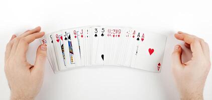 Big deck of cards in the form of a fan on the table and the player's hands photo
