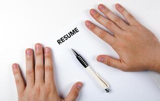 Man's hands on resume form and pen photo