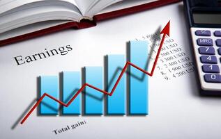 table with earnings with digits, calculator and diagram photo