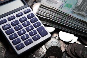 money in the form of banknotes and coins with calculator photo